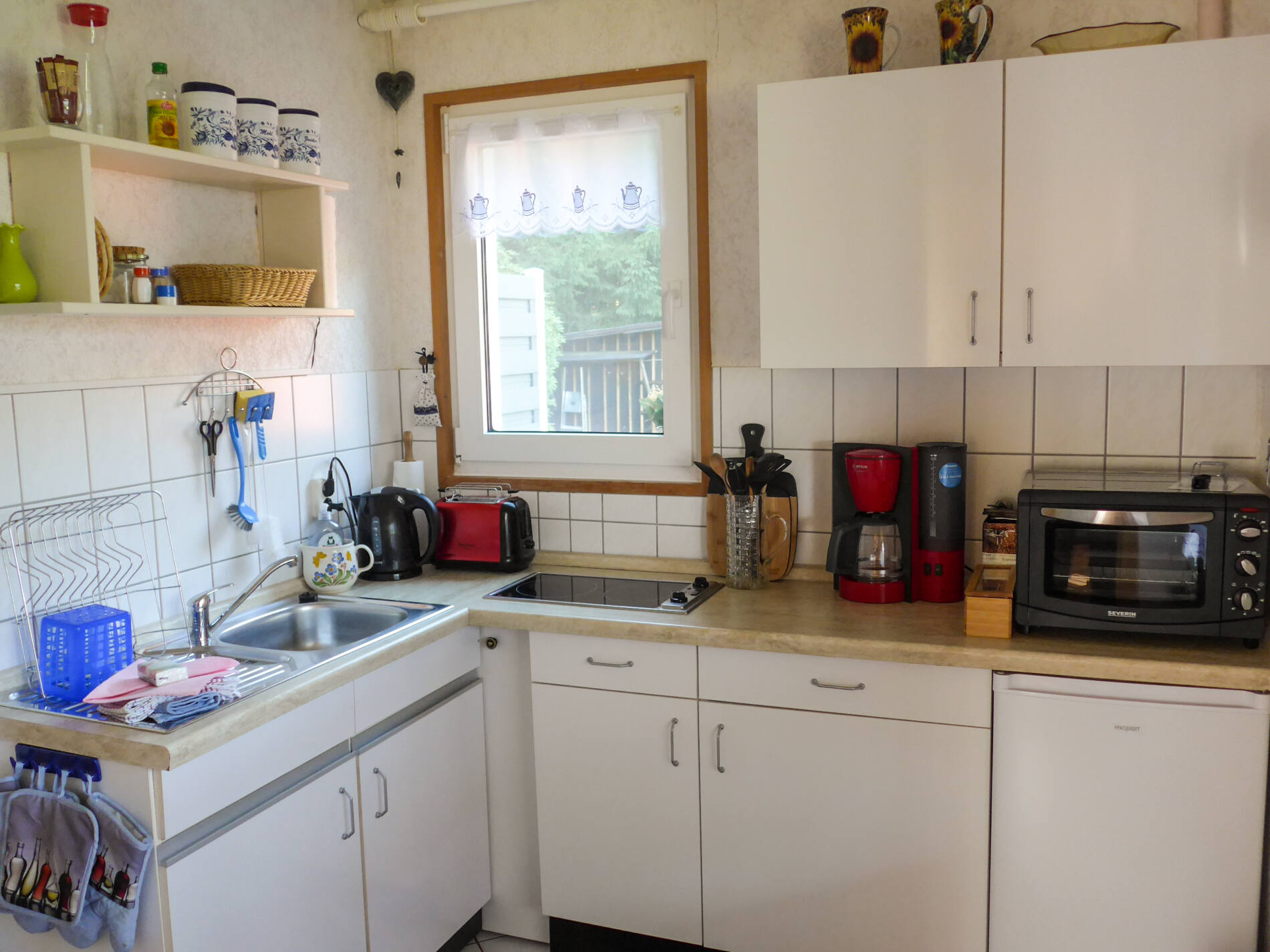 Küche mit Cerankochfeld, Kühlschrank und Minibackofen